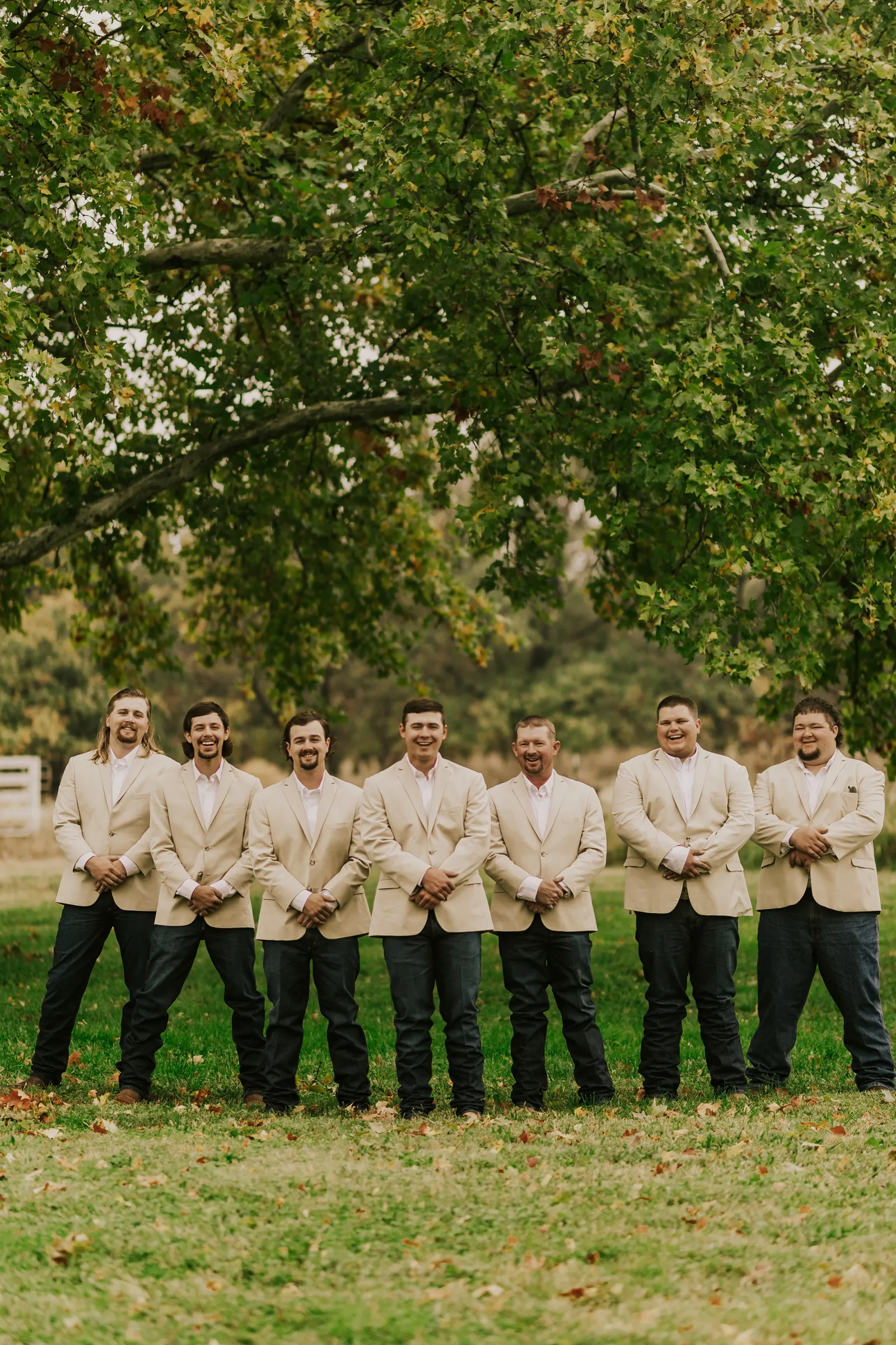 Groomsmen smiling together outside.