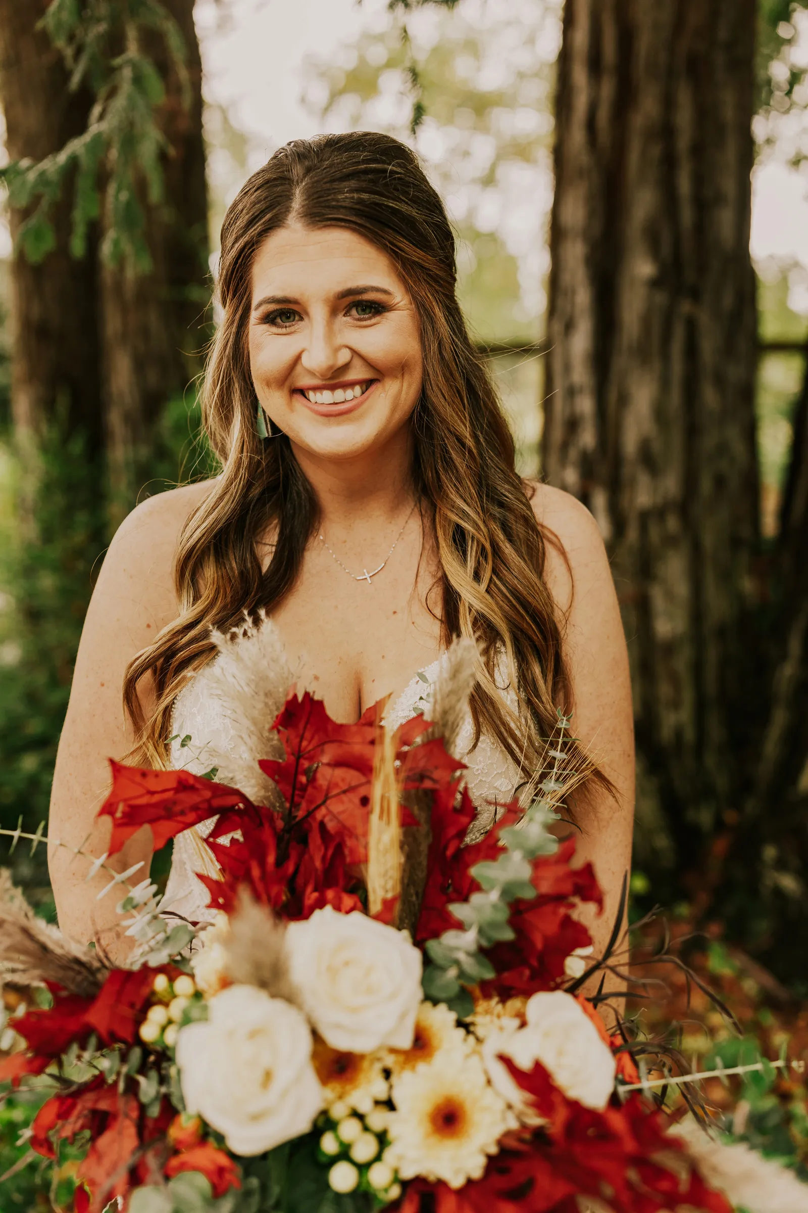 Bride smiling with fall-colored flowers.