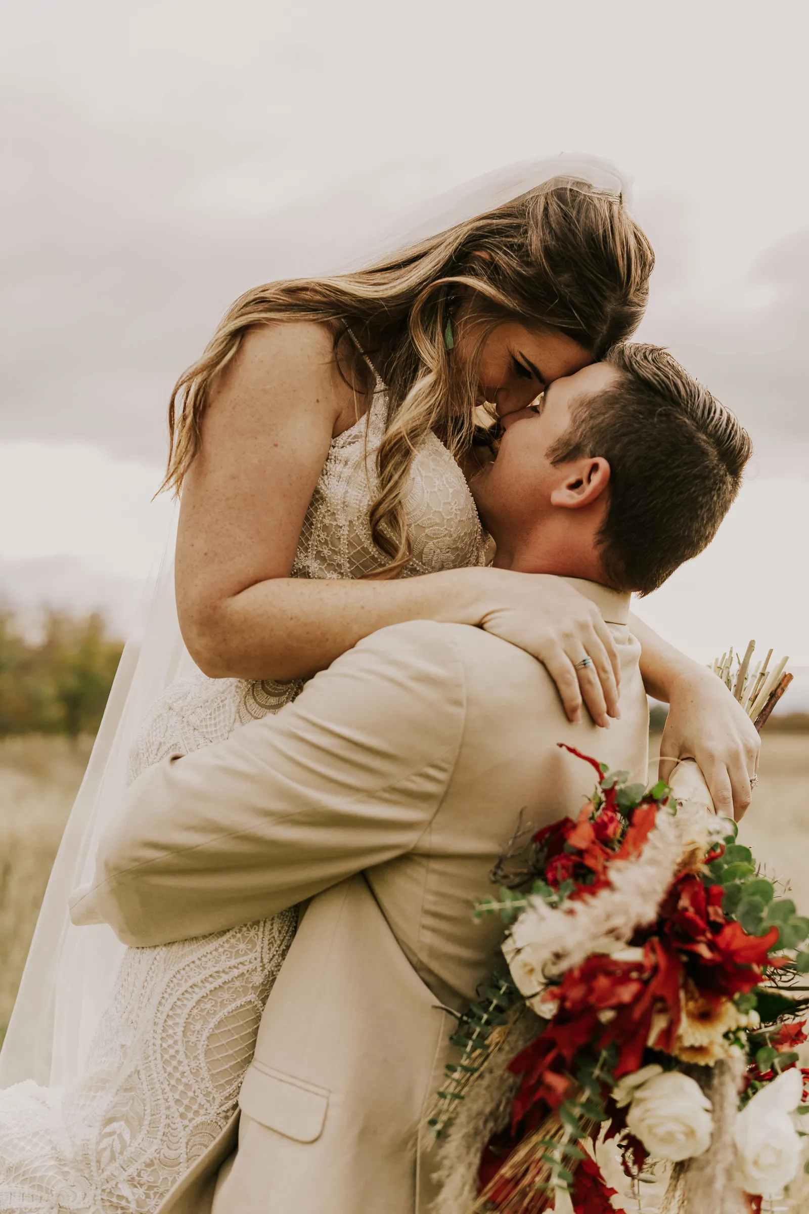 Groom holding up his bride and kissing her.