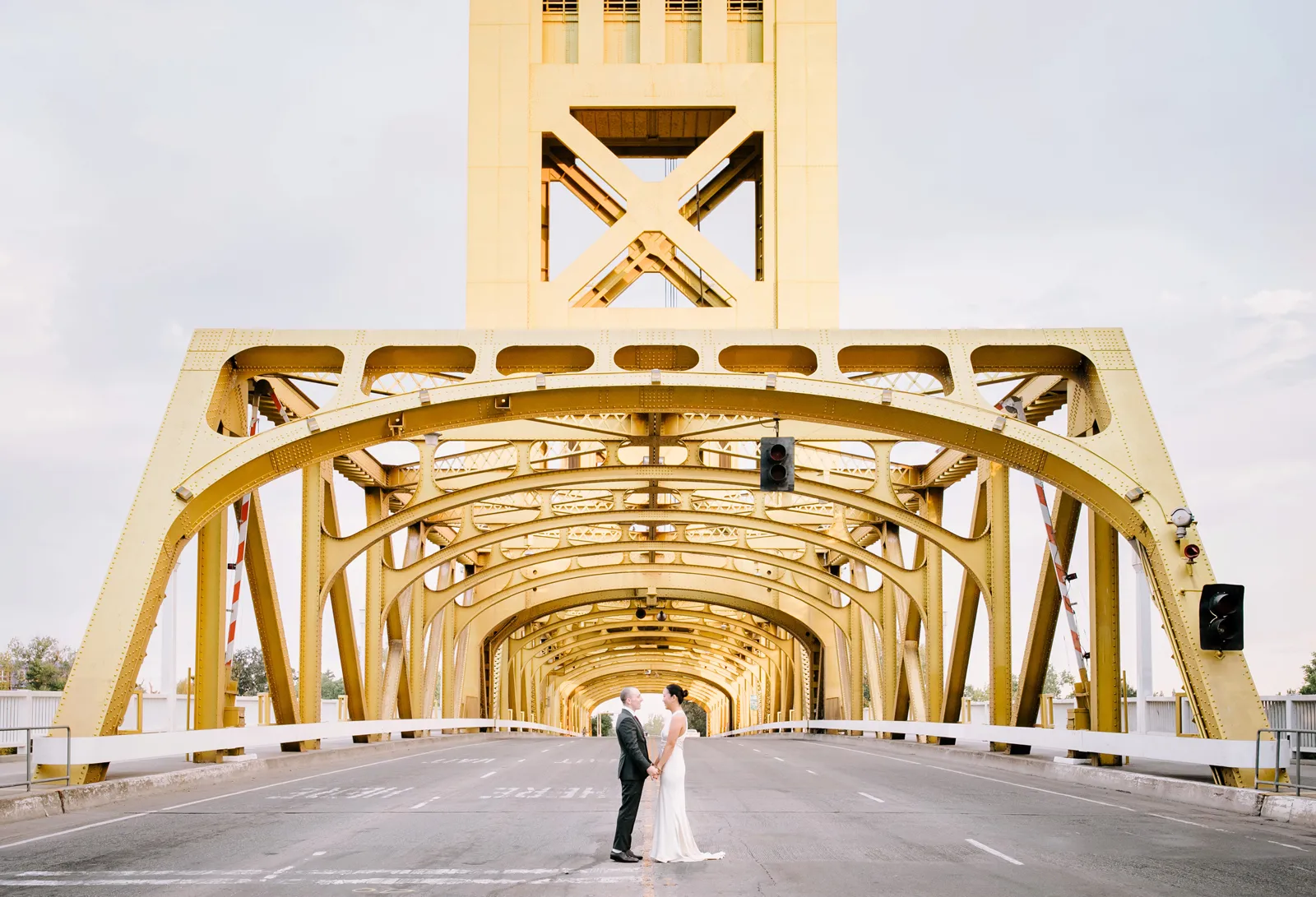 Couple standing in front of a golden bridge for their elopement.