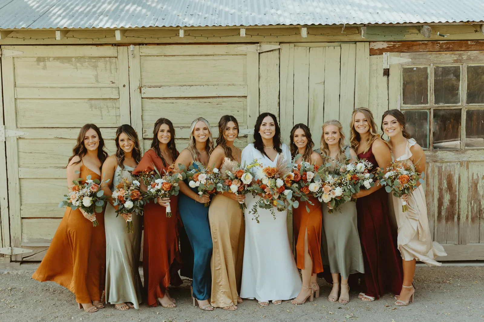 Bride and her bridal party smiling and posing for the camera.