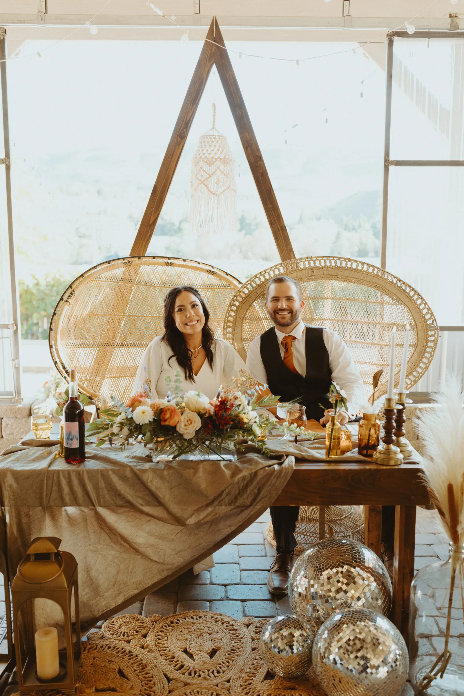 Bride and groom smiling at their table.