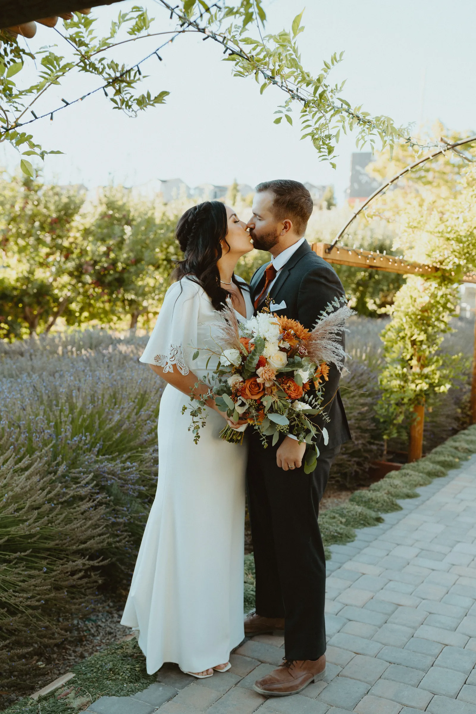 Newlyweds kissing outside for photos.