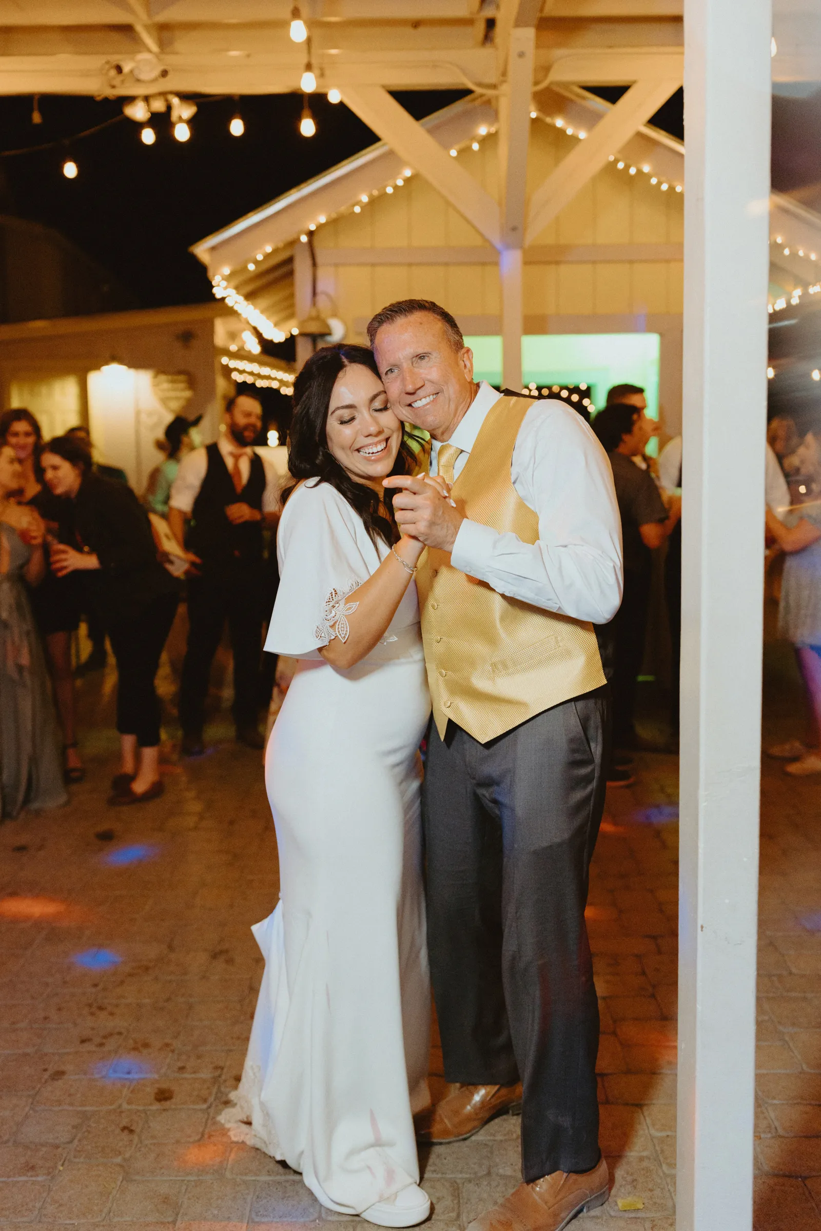 Bride dancing with her father on the dance floor and laughing.