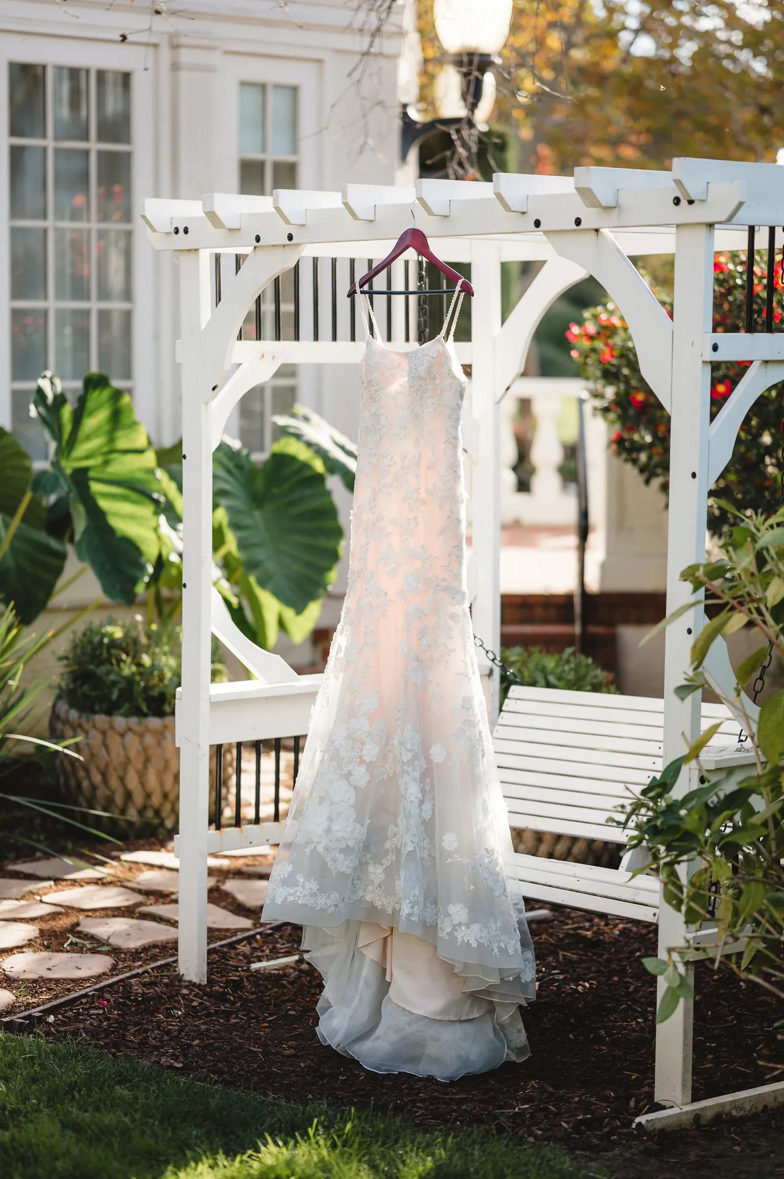 Bridal gown hanging outside on a floating swing.