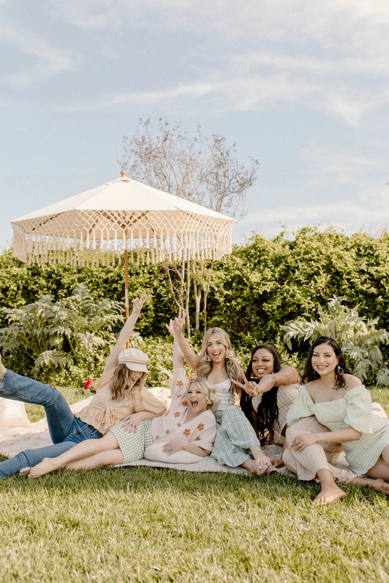 Bachelorette party smiling for the camera by their picnic.