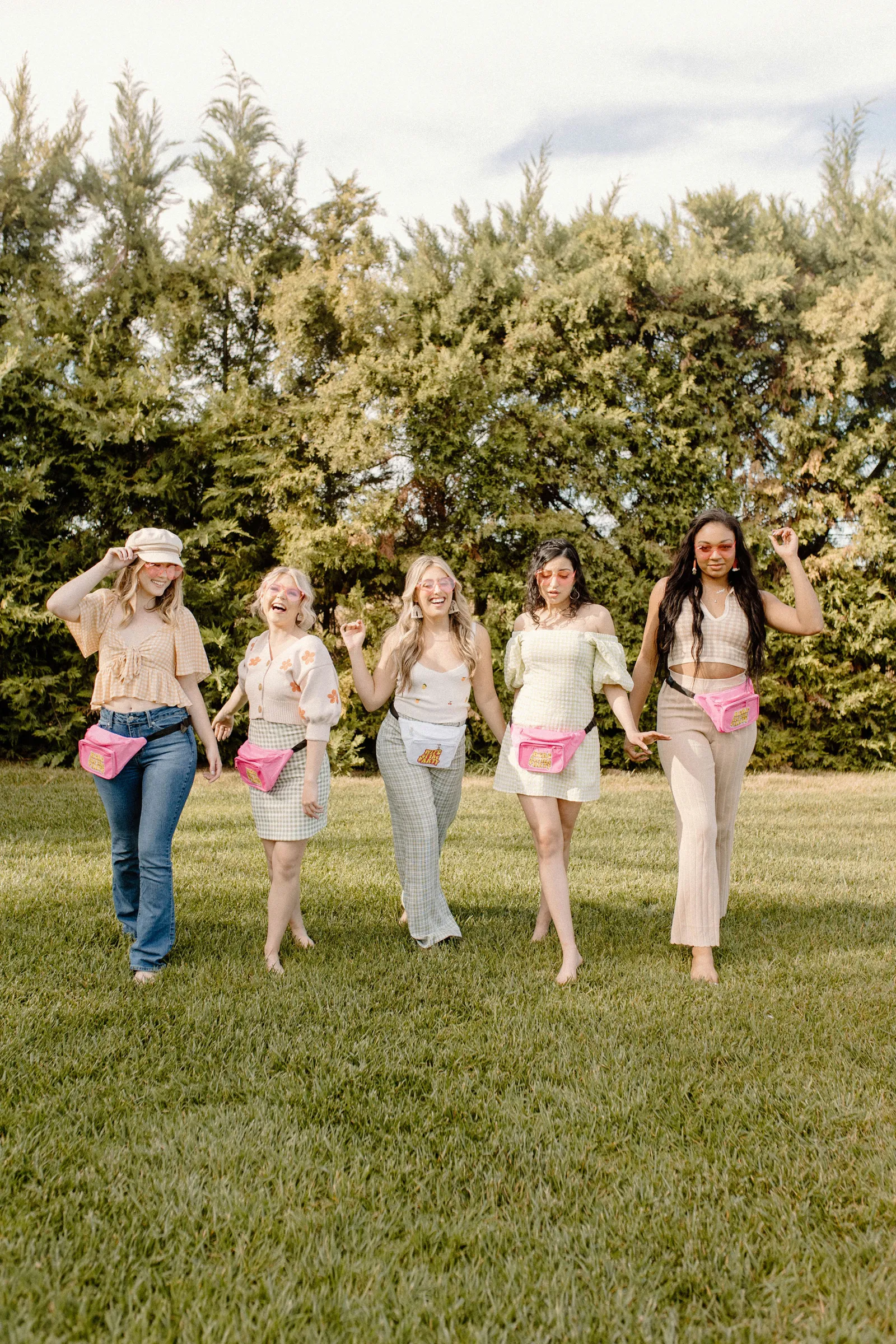 Bachelorette party walking toward the camera with pink fanny packs.