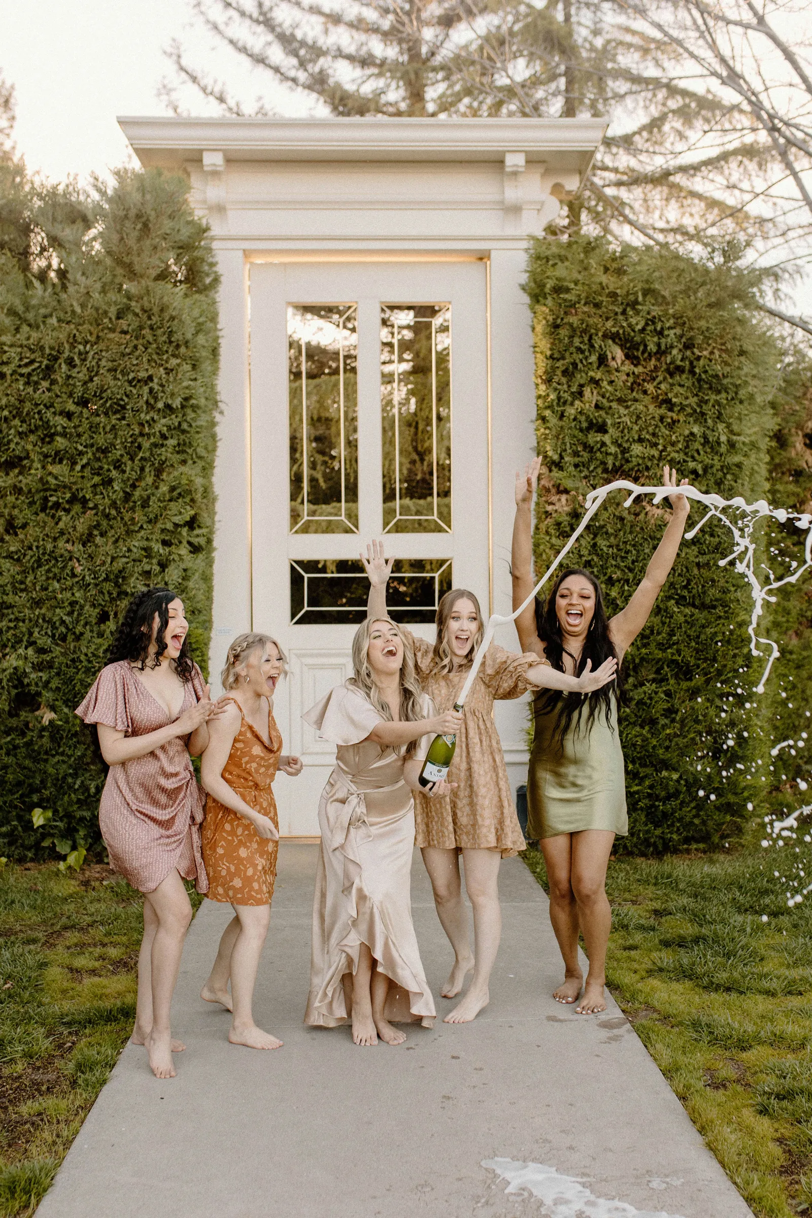 Bachelorette and her friends opening a champagne bottle.