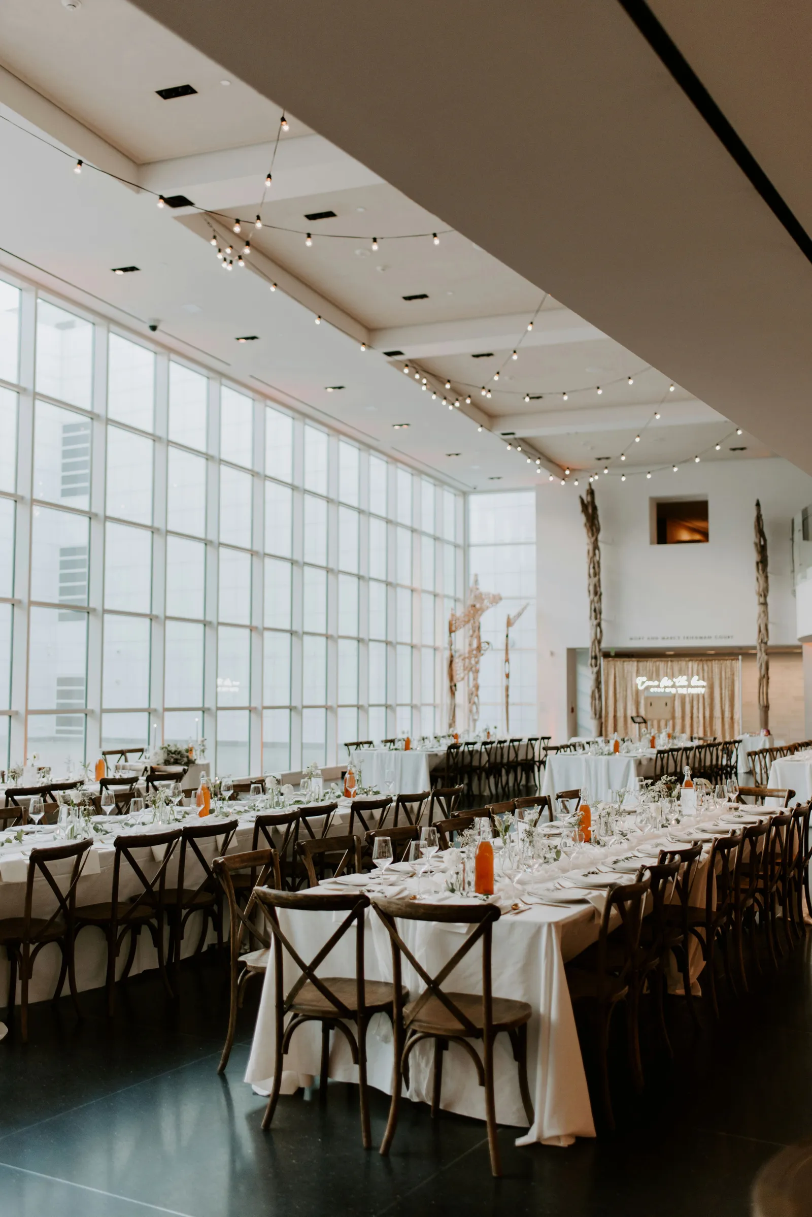 Photo of the reception venue with white tables and dark chairs.