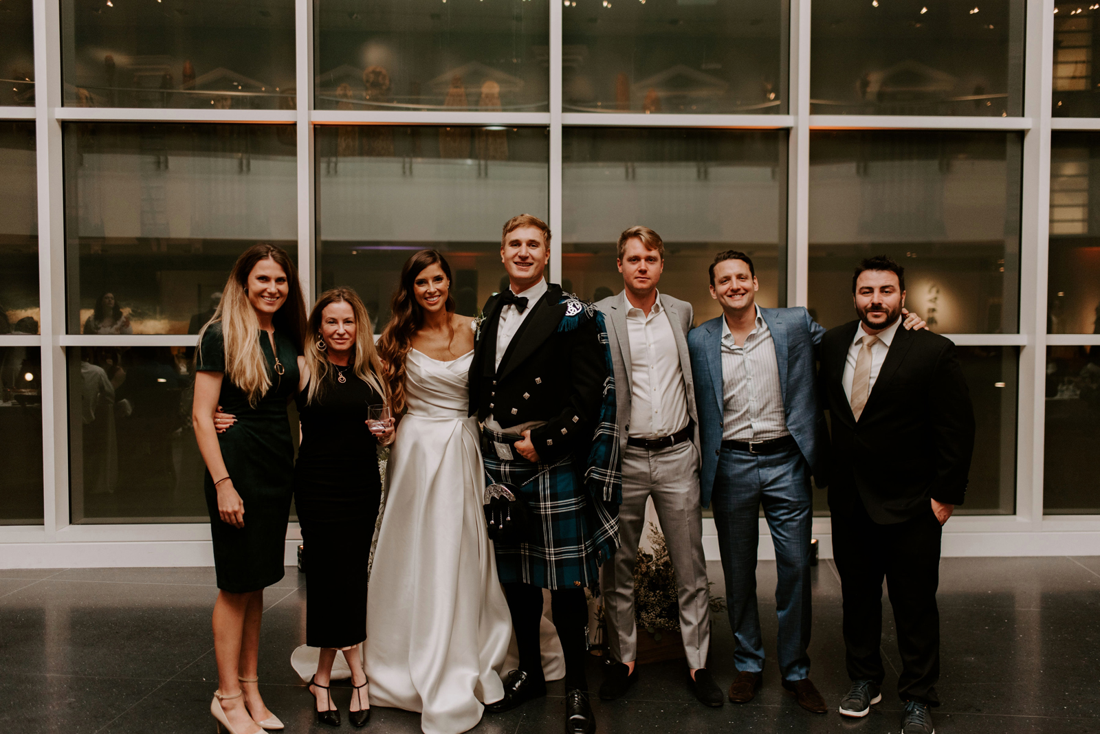 Bride and groom smiling and posing with their friends and family.