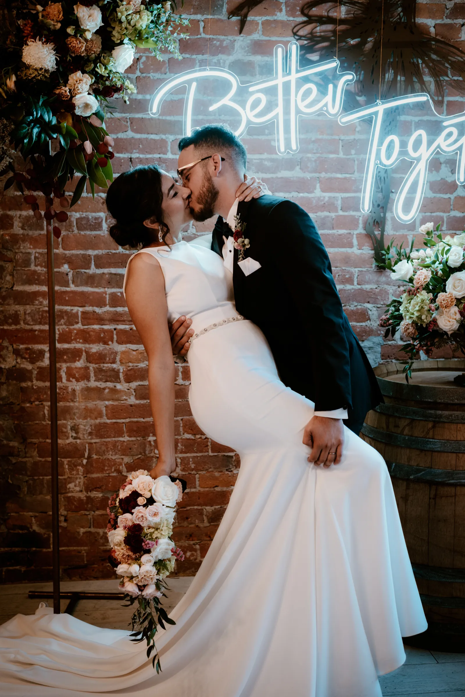 Groom tilting his bride to kiss to her.