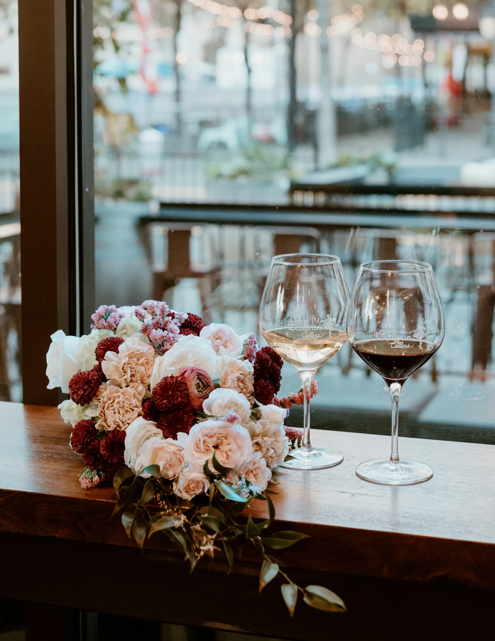 Photo of two glasses of wine with a bouquet next to them.