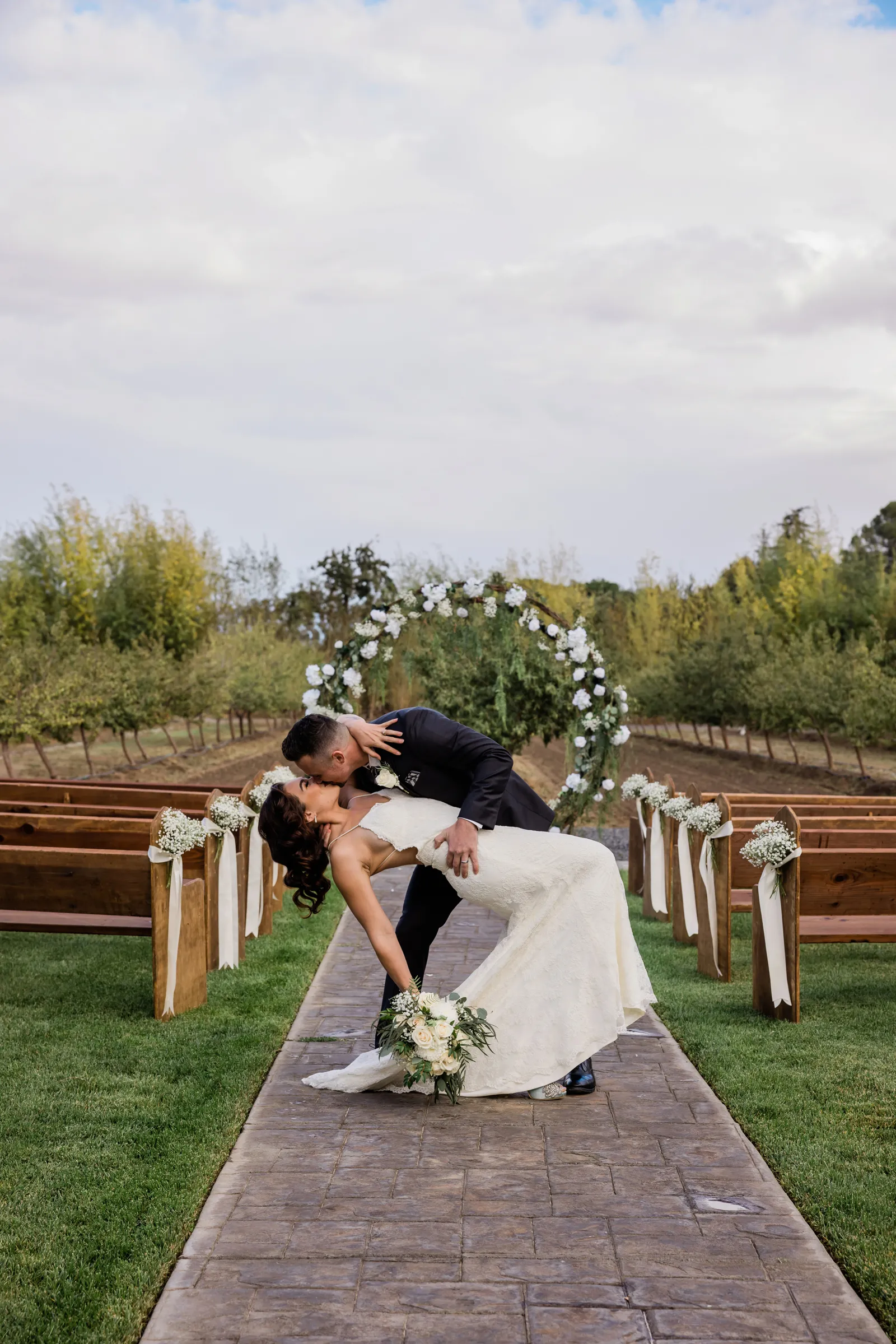 Groom dipping his bride at the beginning of the aisle after celebrating.