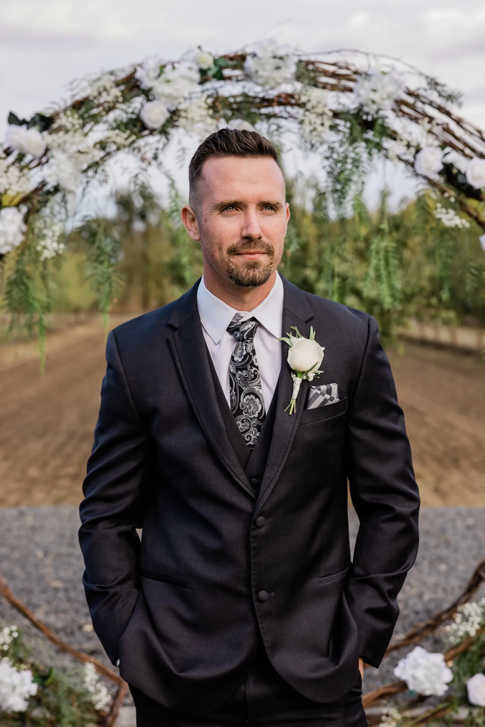 Groom posing solo with his hands in his pockets.