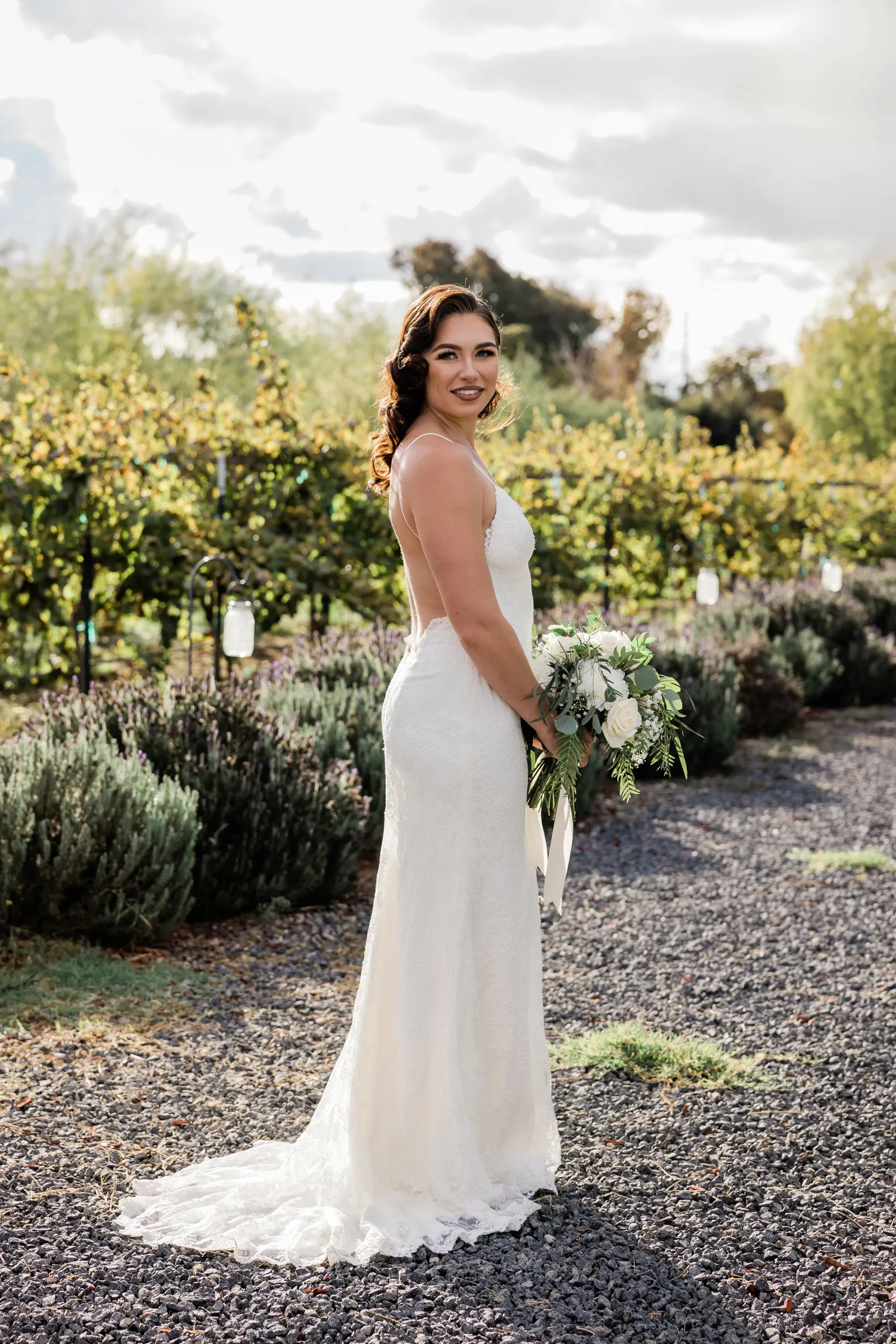 Bride posing away from the camera and looking behind her shoulder.