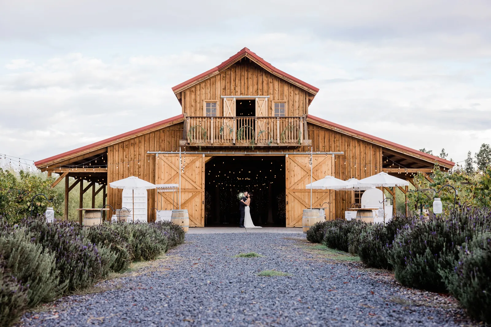 Zoomed out photo of the bride and groom in front of the entrance of the barn.