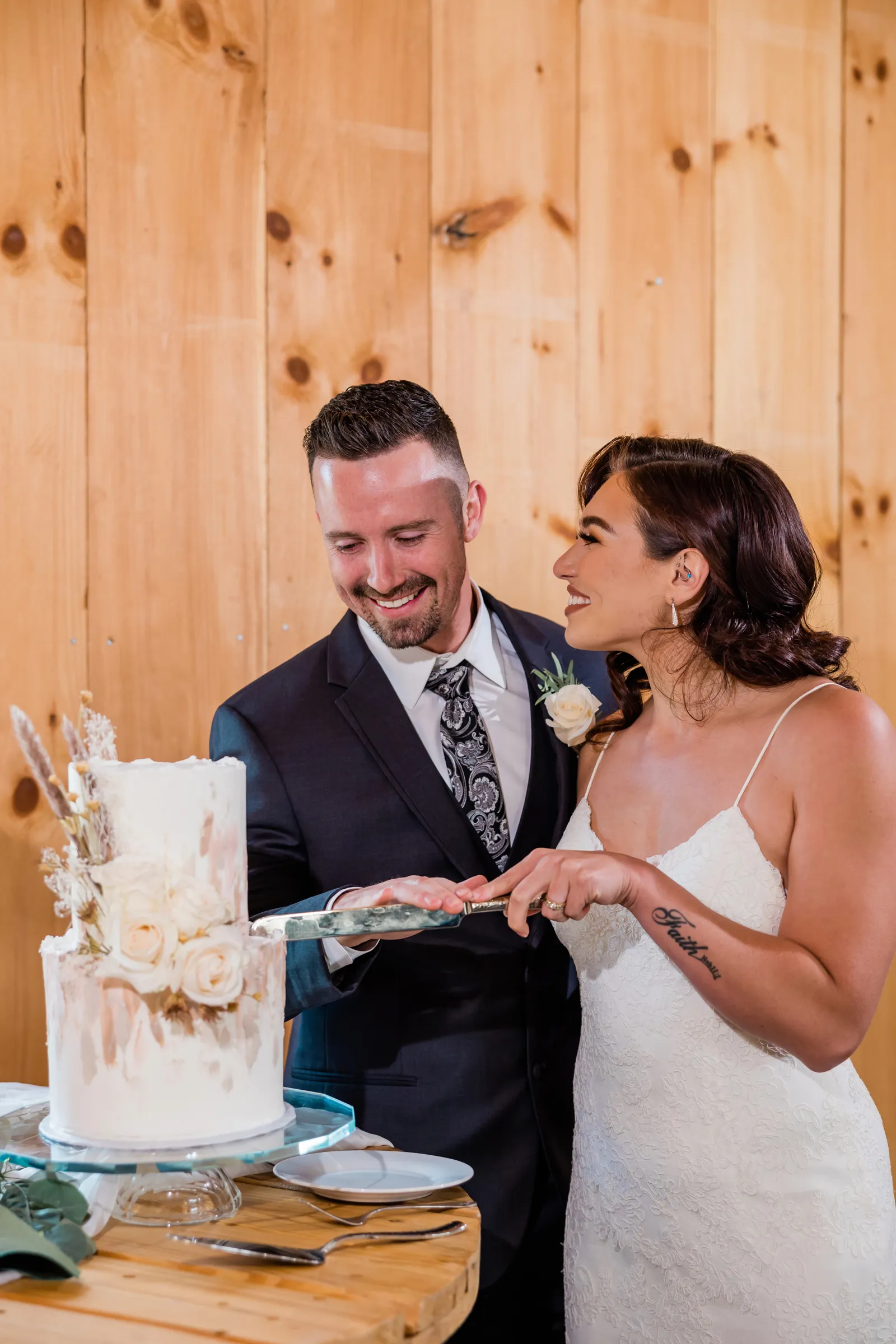 Bride and groom cutting the wedding cake together and laughing.