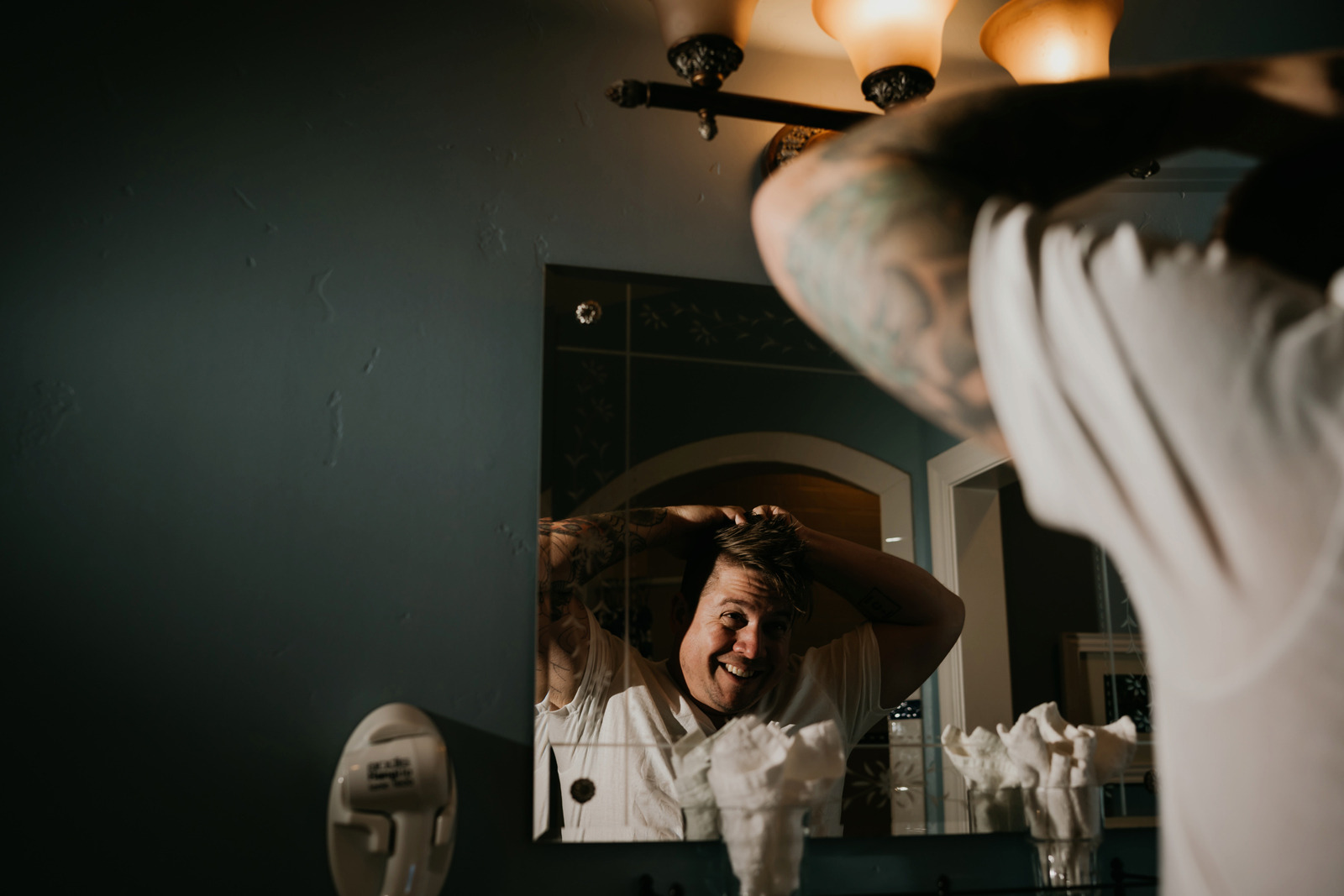 Groom combing his hair in the mirror.