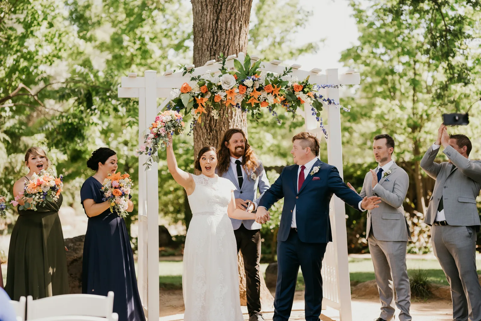 Bride and groom cheering as they walk down the aisle. 