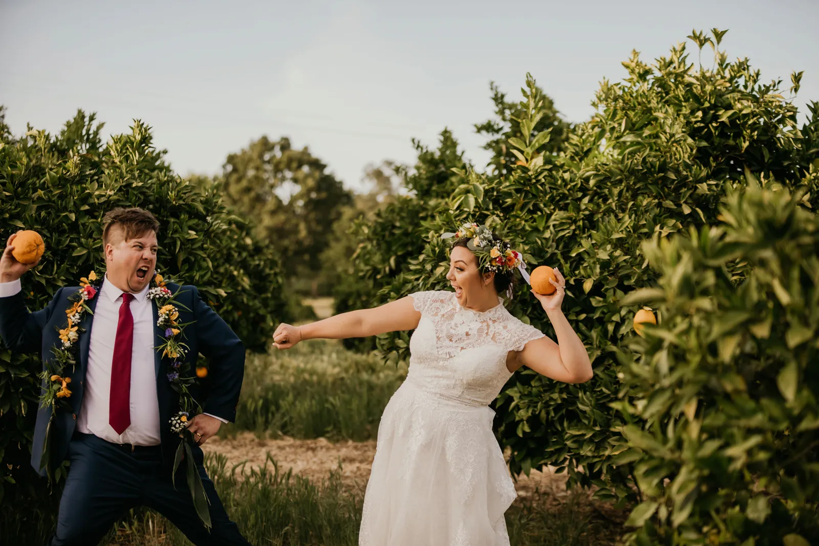 Bride and groom pretending to throw oranges at each other.