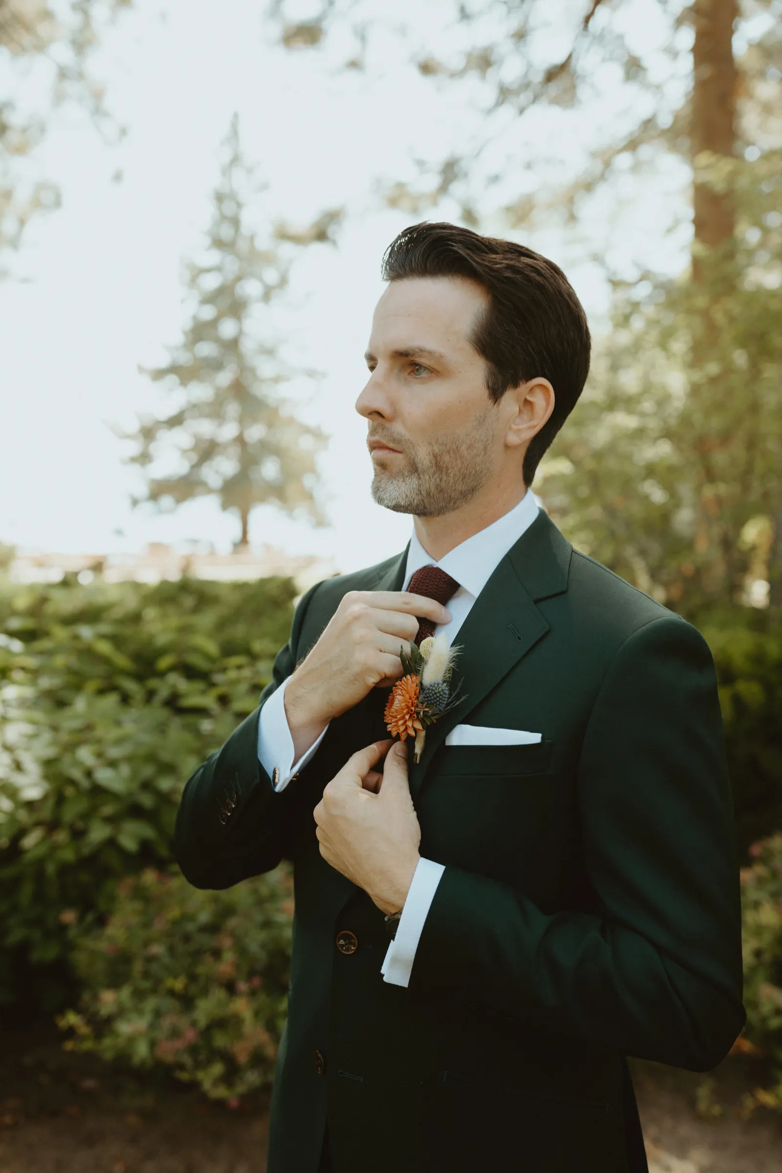 Groom getting ready and fixing his tie.