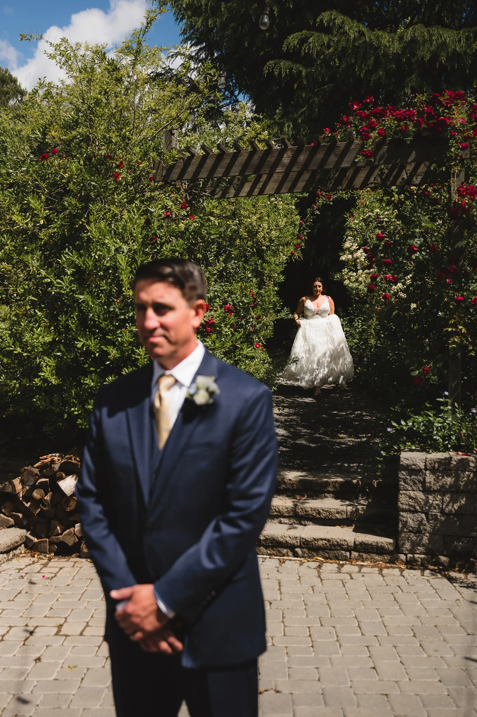 Groom waiting as his bride approaches him for their first look.