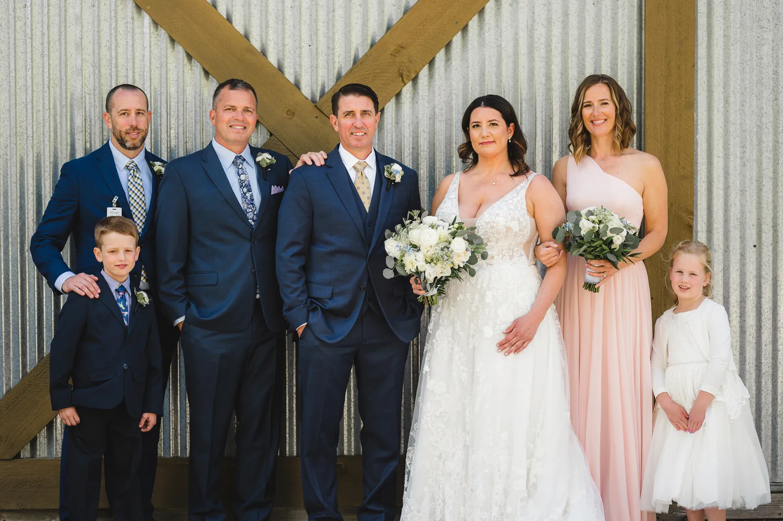 Bride and groom smiling with their party.