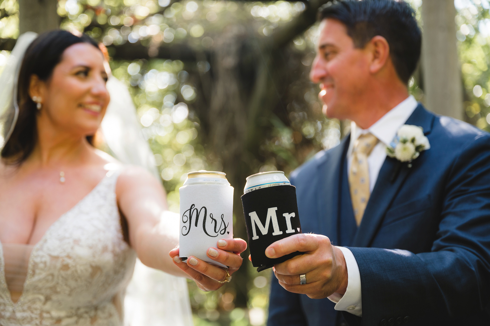 Bride and groom cheersing with their matching coozies.