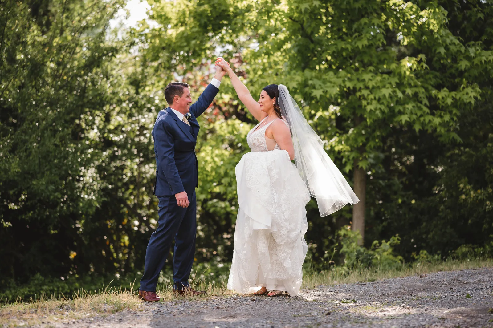 Groom twirling his bride for a photo.