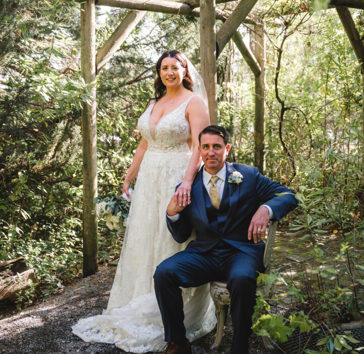 Bride and groom posing in a garden.