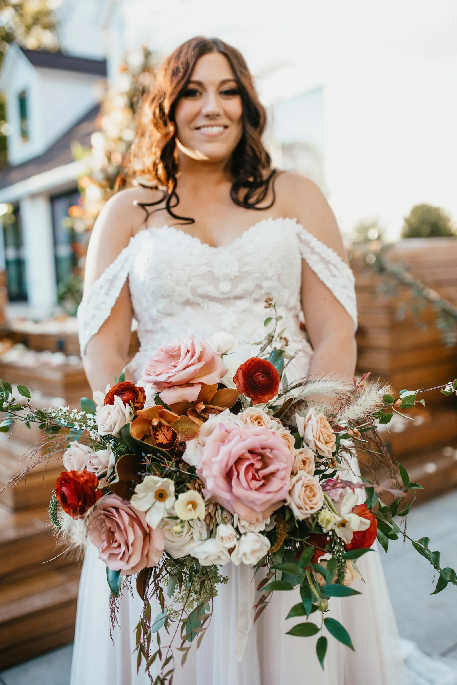 Bride smiling at the camera, holding her bouquet.