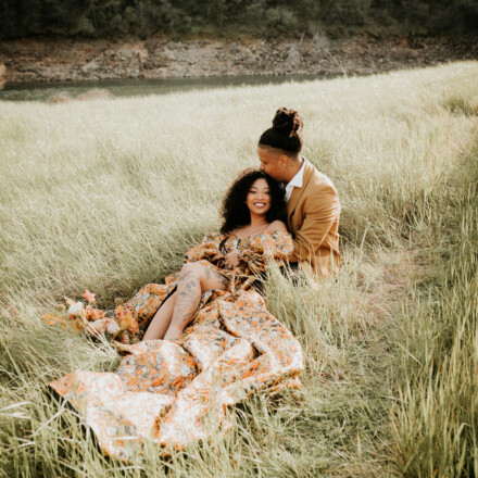 Bride and groom sitting together on the hill at Salmon Falls.