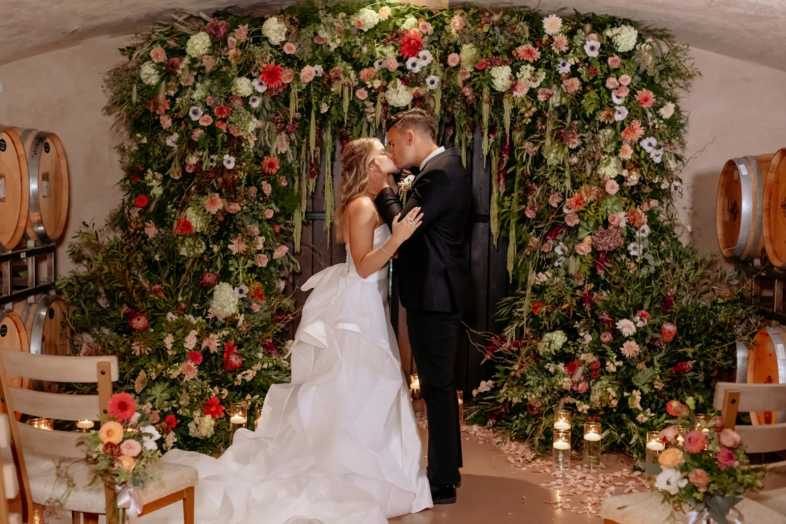 Couple kissing by flowers done by Thistle Bee Florals.