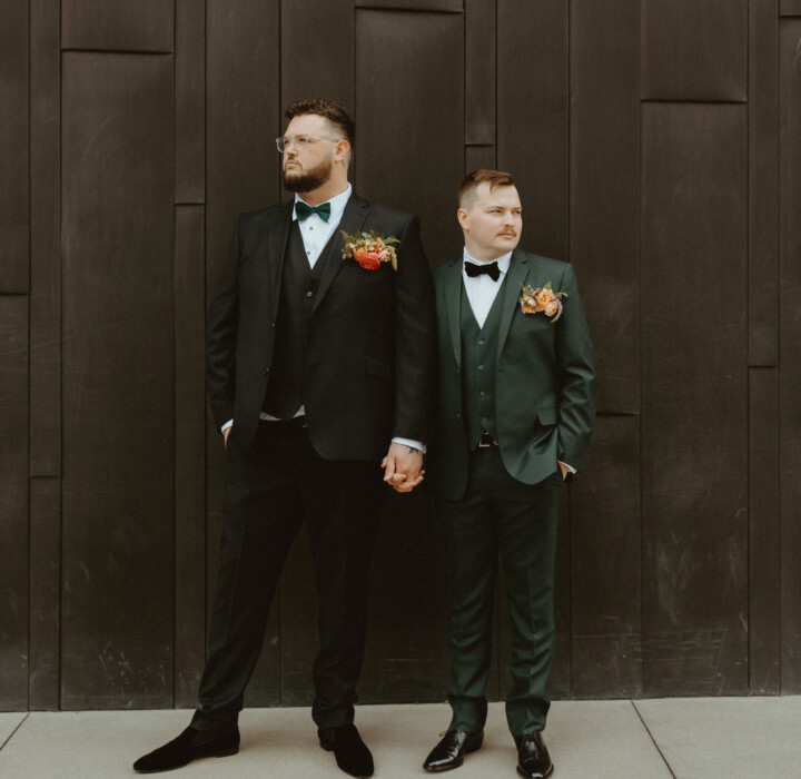 Newlyweds posing together for their industrial chic wedding photos.