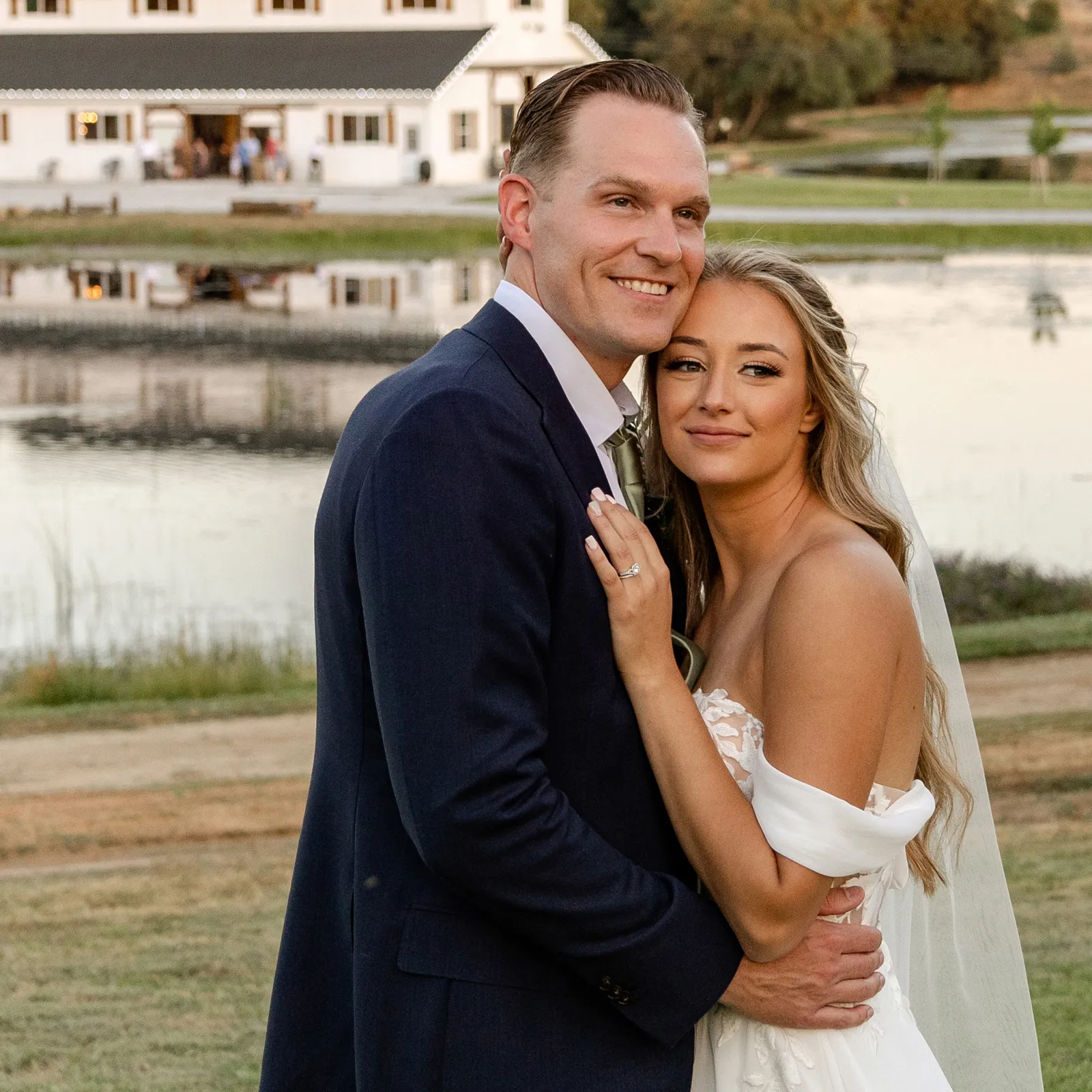 Newlyweds posing together at their outdoor wedding.