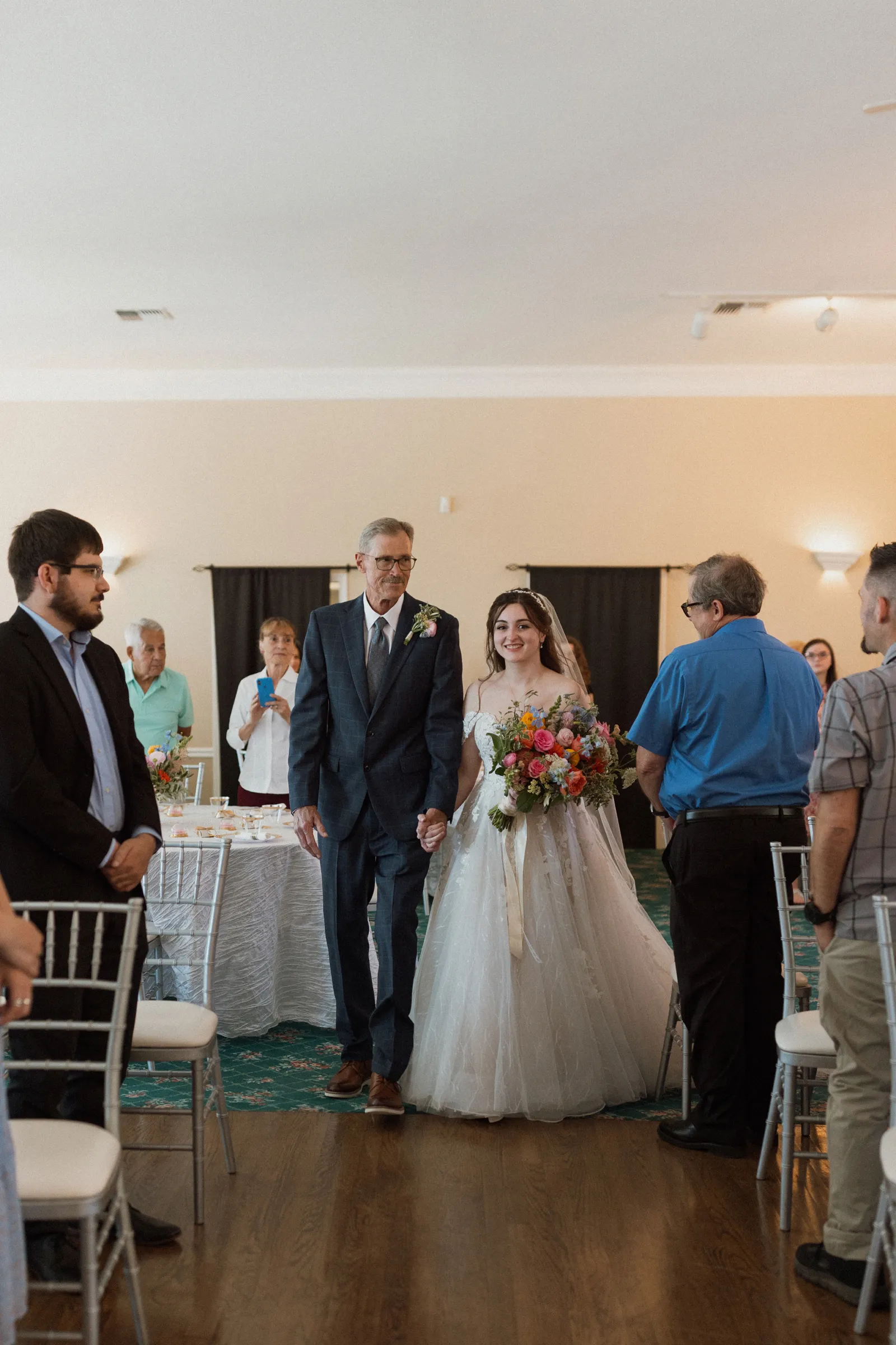 Father walking the bride down the aisle at her estate wedding.