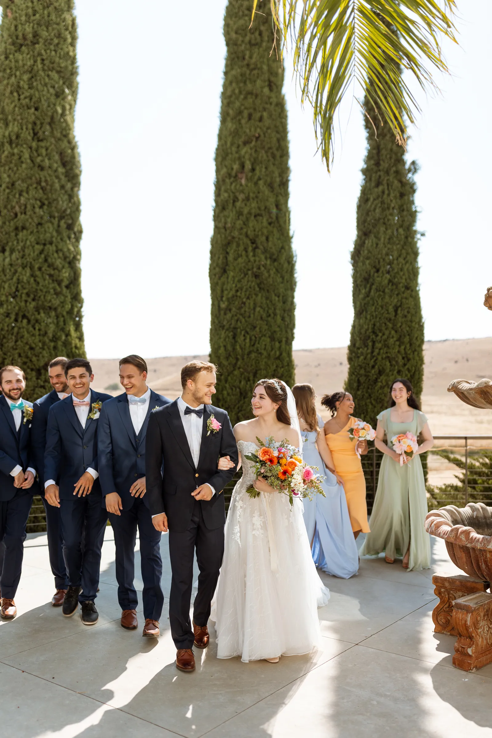 Bride and groom taking wedding photos with their bridal party at their estate wedding.