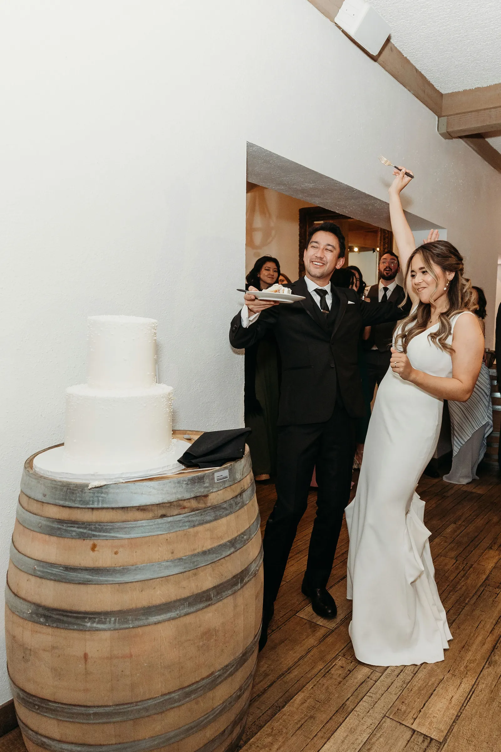 Newlyweds cutting their wedding cake together at Wente Vineyards wedding venue.