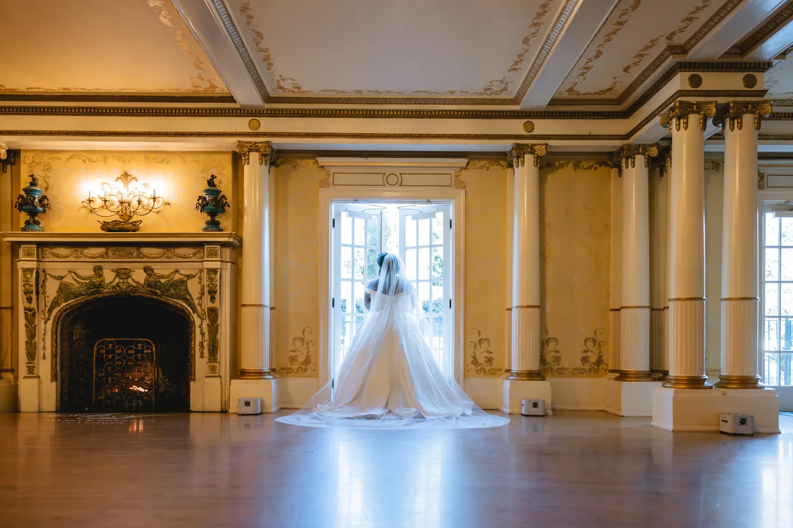 Bride posing near the open doors of her beautiful mansion wedding.