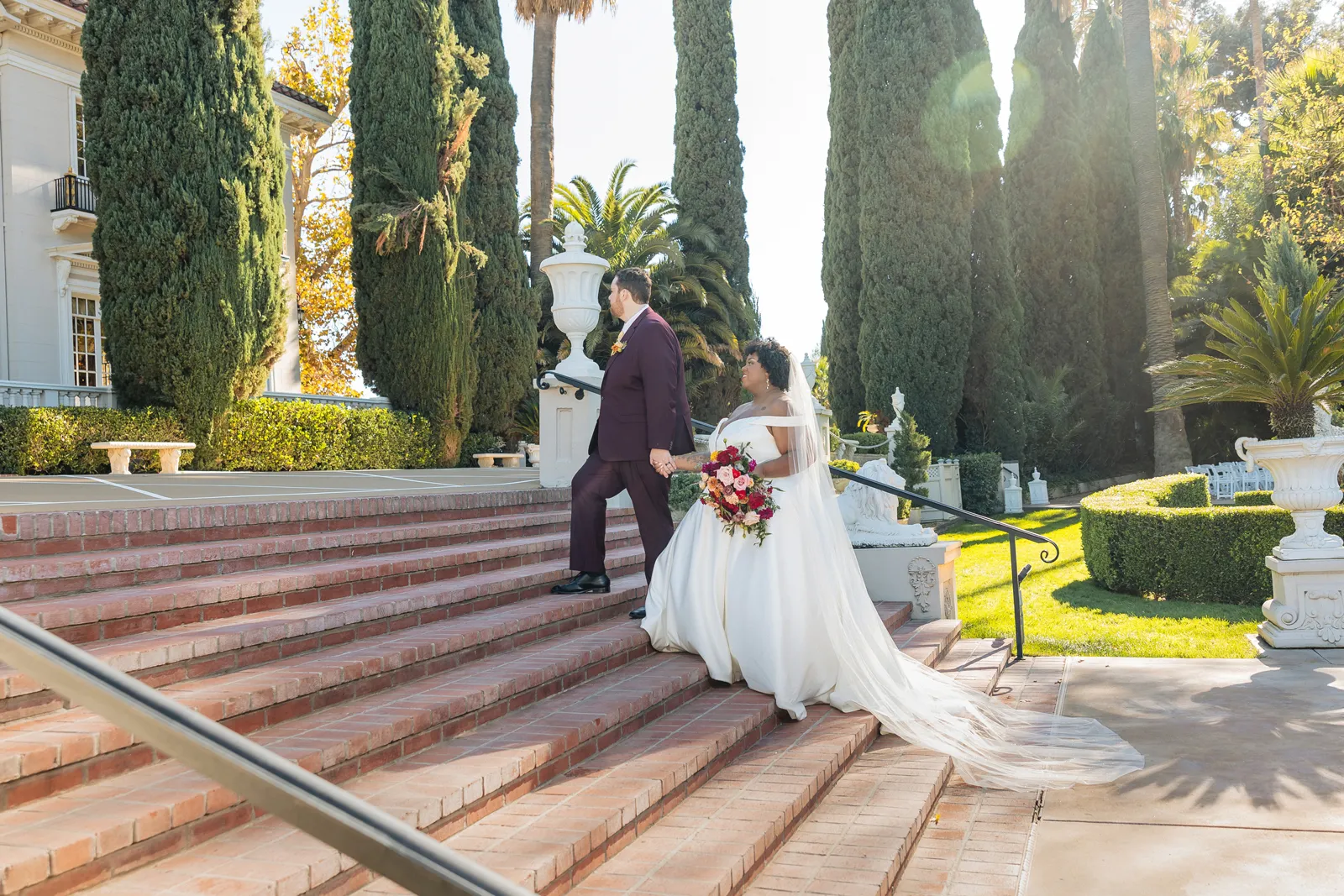 Newlyweds walking up the stairs together at their beautiful mansion wedding.