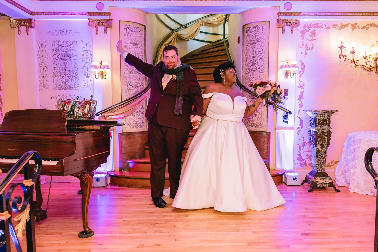 Newlyweds walking into the reception at the Grand Island Mansion wedding venue.