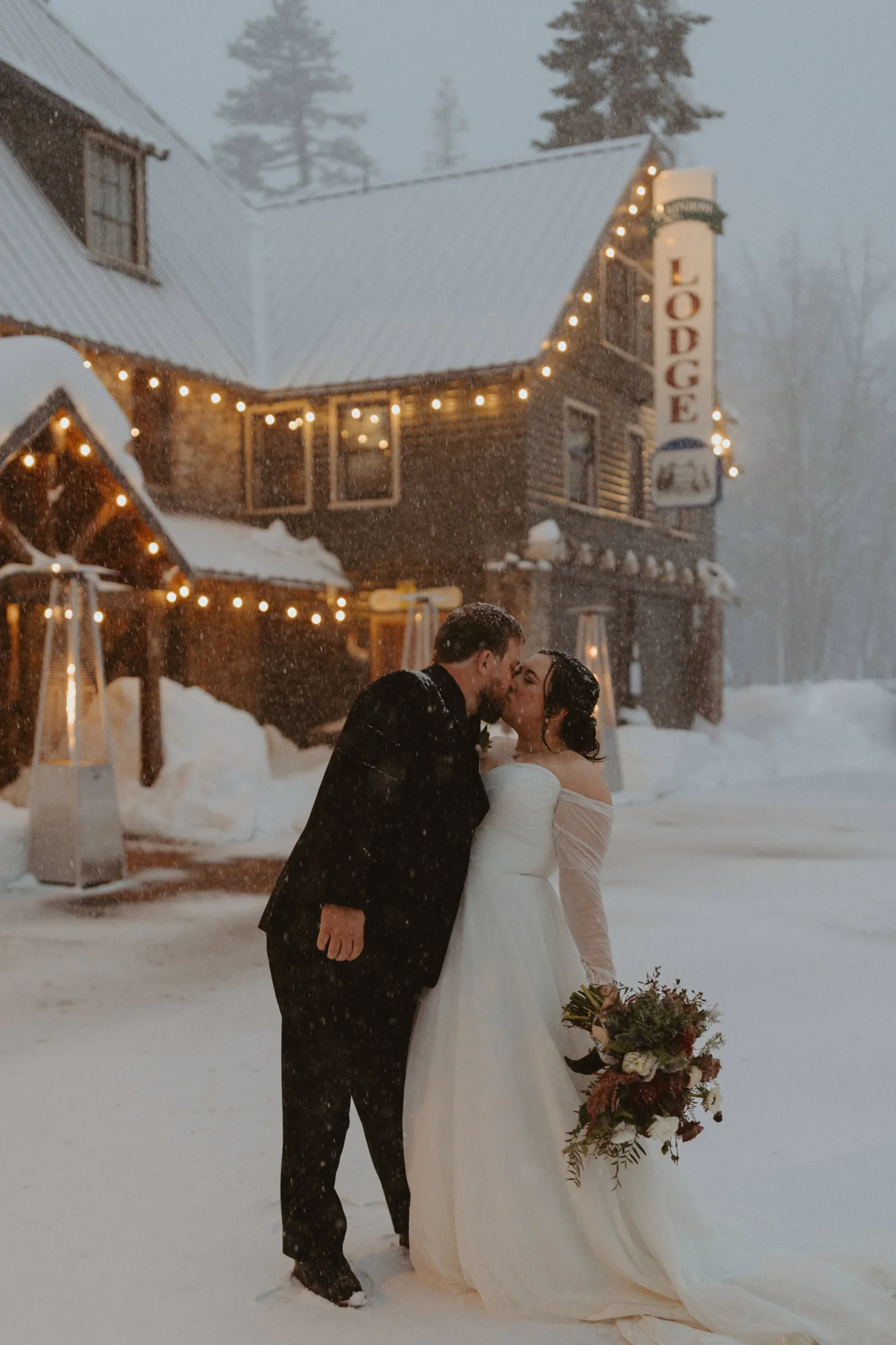 Bride and groom posing together in front of their ski lodge wedding venue in Lake Tahoe.